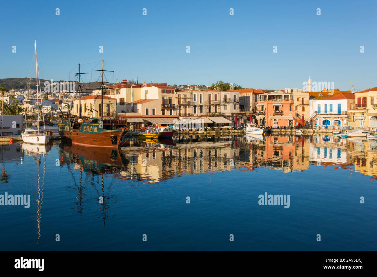 Rethymno, Creta, Grecia. Vista sul porto veneziano all'alba, edifici colorati che si riflettono nell'acqua. Foto Stock