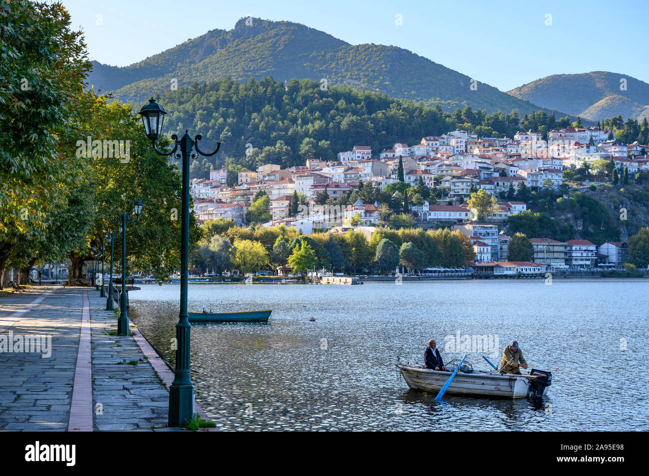 Guardando attraverso il lato nord del lago Orestiada con la città di Kastoria in background, Macedonia, Grecia settentrionale. Foto Stock