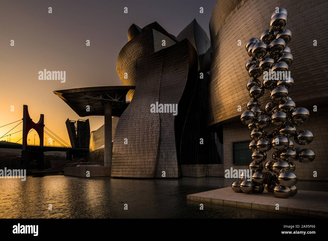 La scultura 80 sfere di acciaio inossidabile da Anish Kapoor al di fuori degli illuminati Museo Guggenheim a sunrise, Nervión River, Bilbao, Paesi Baschi Foto Stock