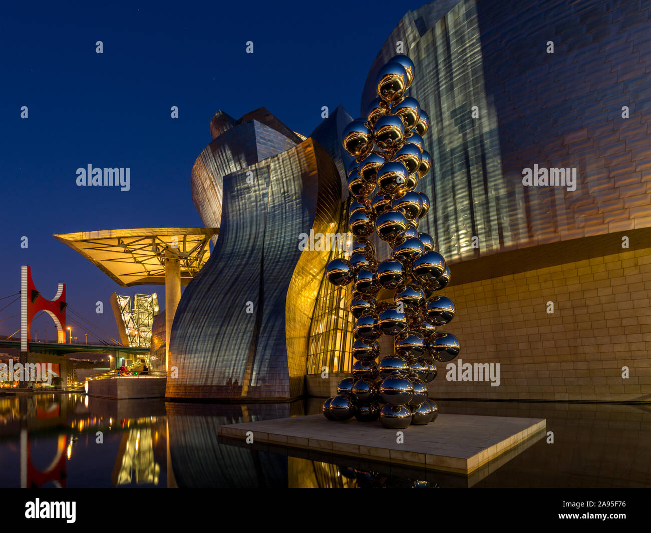 La scultura 80 sfere di acciaio inossidabile da Anish Kapoor al di fuori degli illuminati Museo Guggenheim a sera, Nervión River, Bilbao, Paesi Baschi Foto Stock
