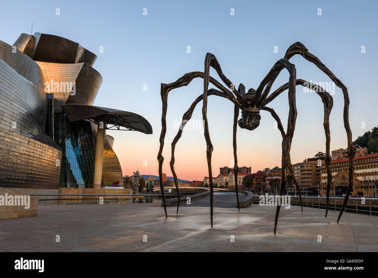 Maman spider scultura dell'artista Louise Bourgeois al di fuori del Museo Guggenheim appena dopo il tramonto, Nervión River, Bilbao, Paesi Baschi Foto Stock