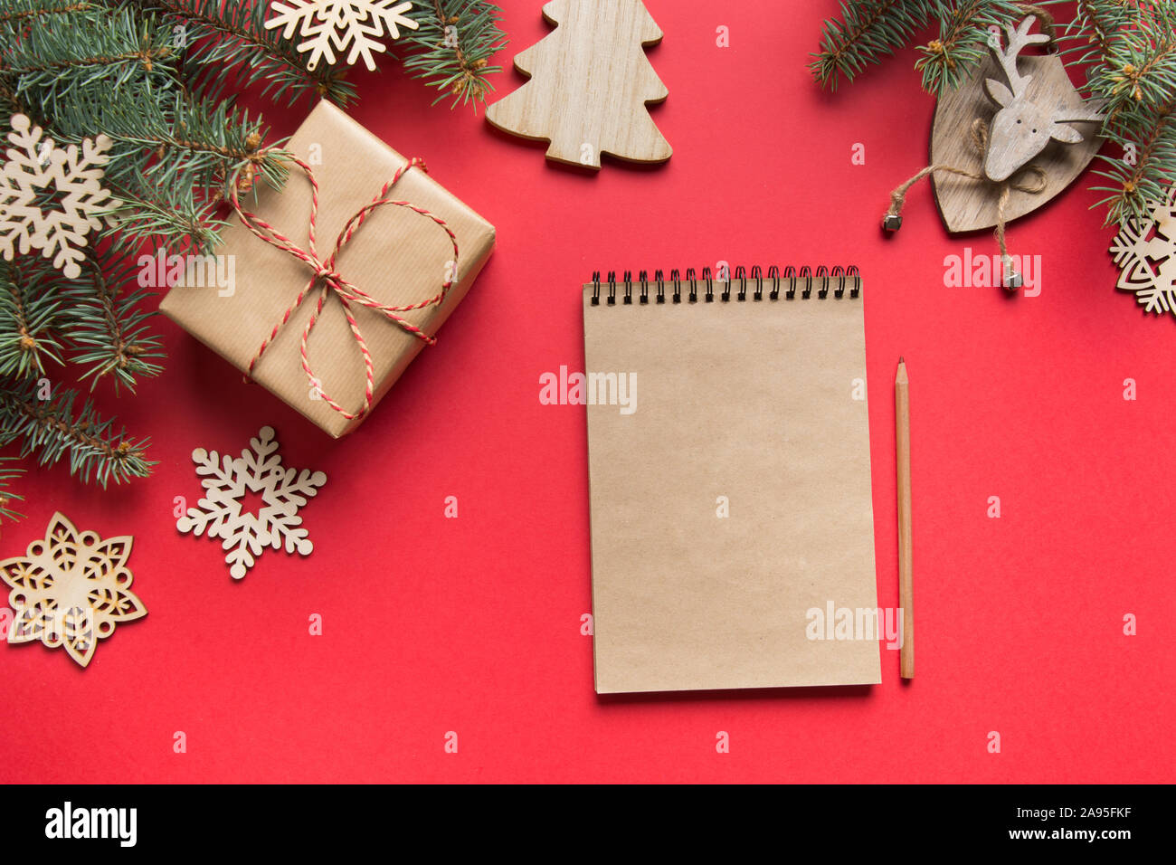 Zero rifiuti Nozione di Natale. Obiettivi, checklist, piani per il nuovo anno. Lista dei desideri Lista da fare per il 2020 anno con legno arredamento naturale sul rosso. Vista dall'alto. Fl Foto Stock