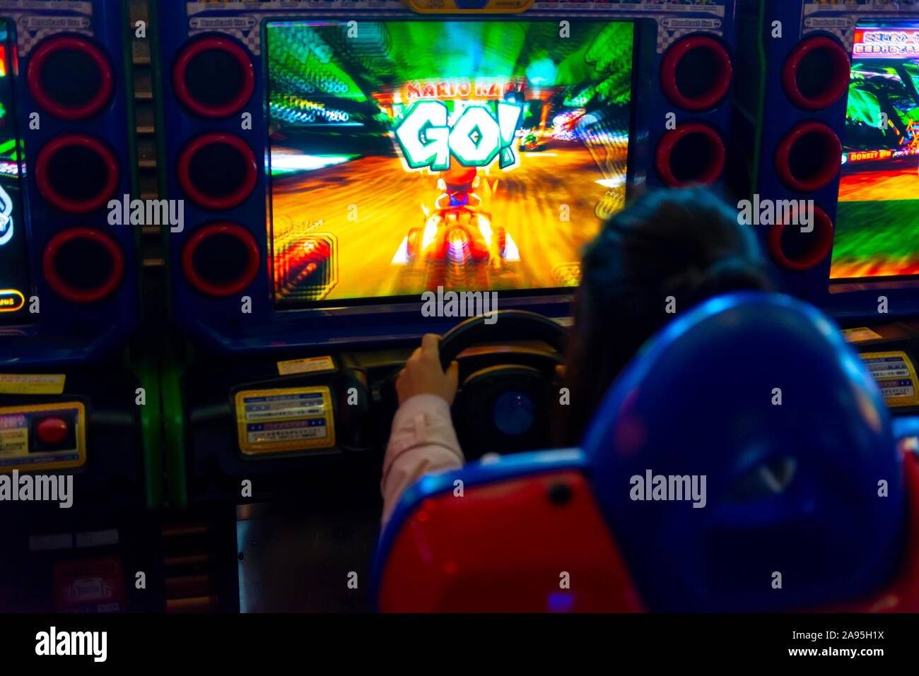 Adolescente svolge un car racing game, Mario Kart, arcade Anata no magazzino, cyberpunk, Kawasaki, Giappone Foto Stock