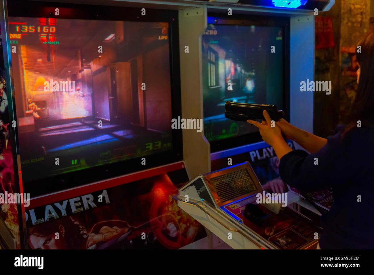 Persona detiene la pistola per il controllo di un gioco per computer, arcade Anata no magazzino, cyberpunk, Kawasaki, Giappone Foto Stock