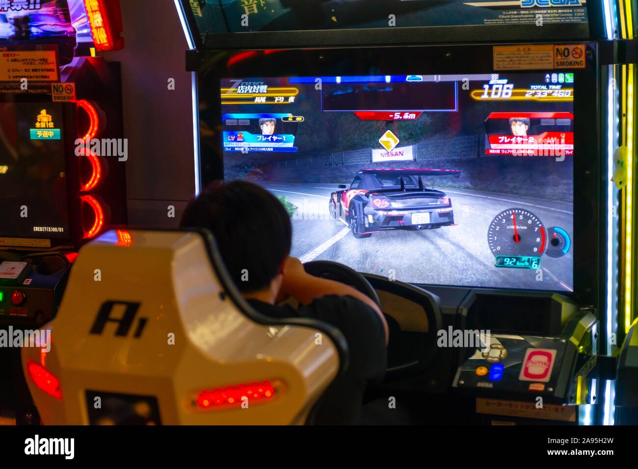 Adolescente svolge un car racing game arcade Anata no magazzino, cyberpunk, Kawasaki, Giappone Foto Stock