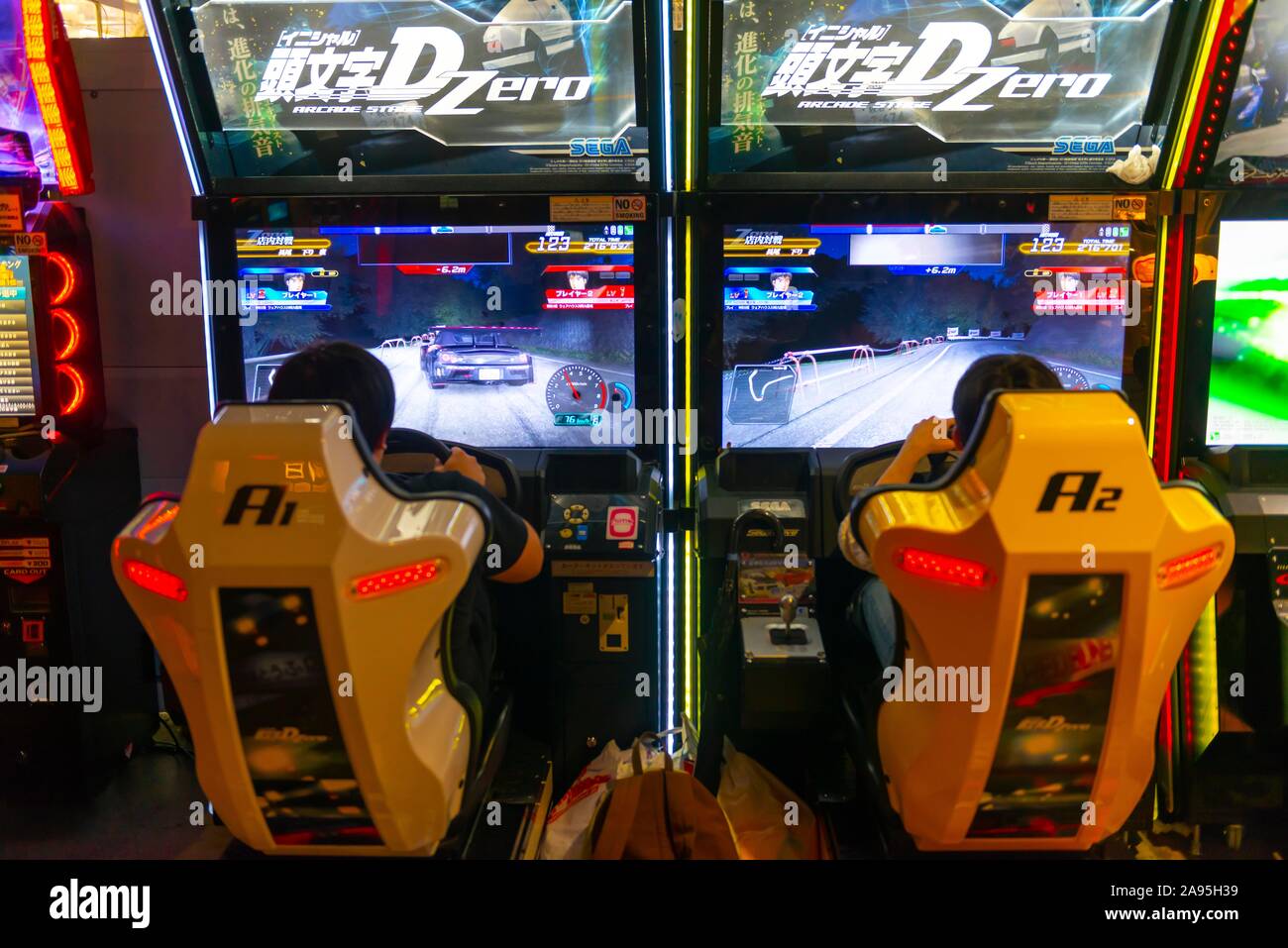Gli adolescenti giocare un auto da corsa gioco insieme, arcade Anata no magazzino, cyberpunk, Kawasaki, Giappone Foto Stock