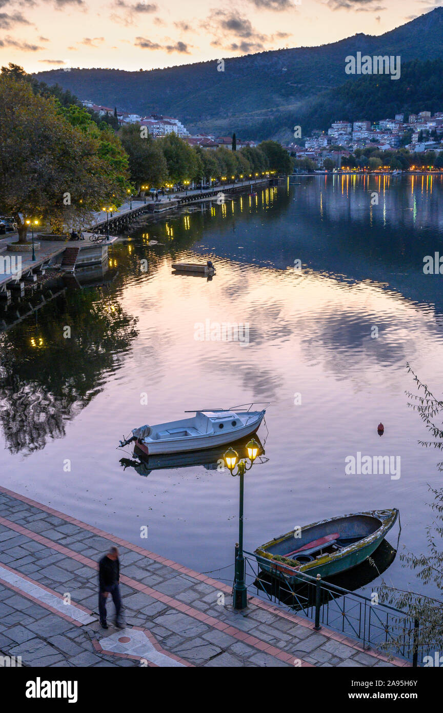 Luce della Sera Sul lungomare nord in Kastoria, guardando attraverso il lago Orestiada con la città sullo sfondo, Macedonia, Grecia settentrionale. Foto Stock