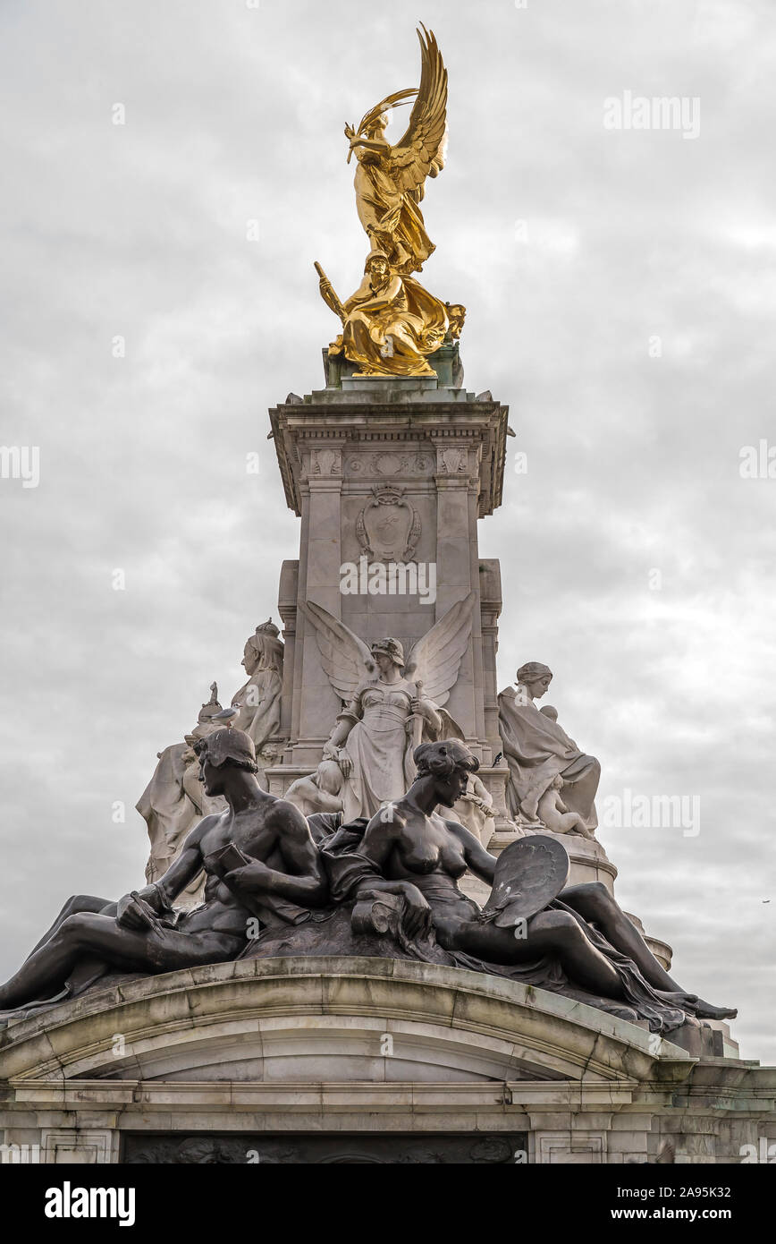 Ritratto, angolo basso vicino al Queen Victoria Memorial fuori da Buckingham Palace, Londra, Regno Unito; statua in marmo Giustizia (di fronte Green Park) sulla vista. Foto Stock