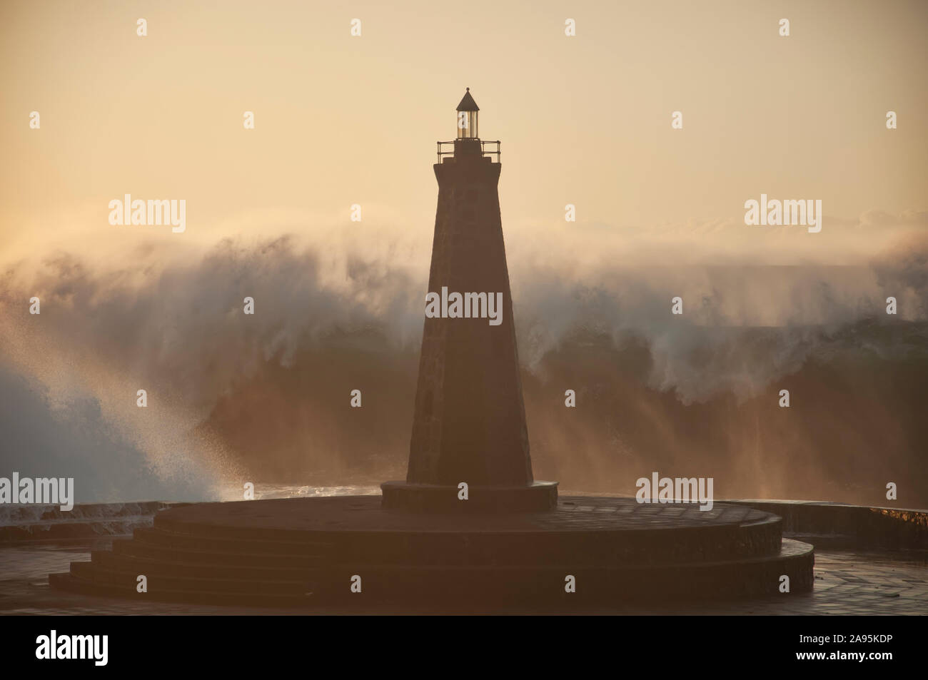 Le onde contro il faro Foto Stock