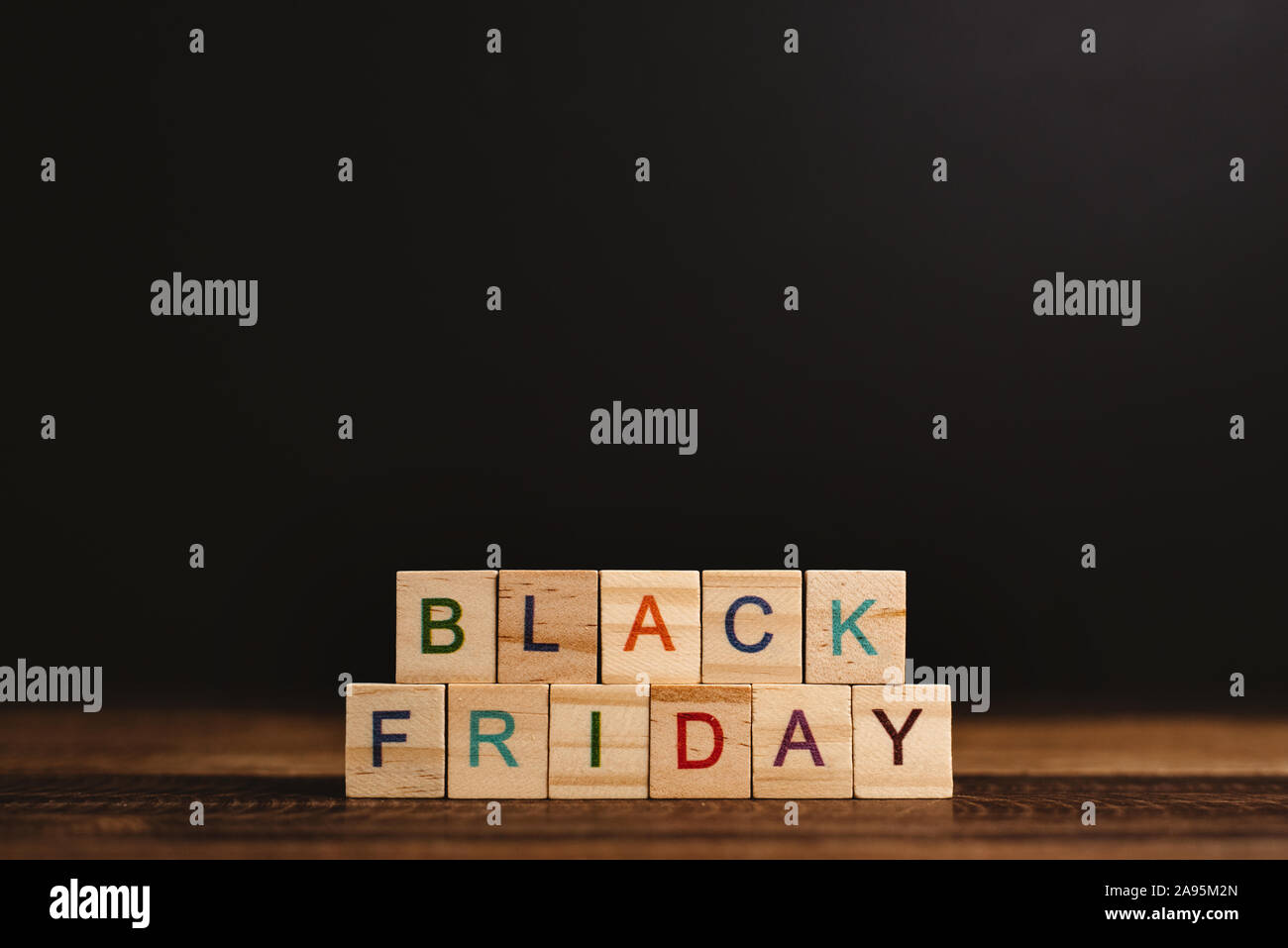 Venerdì nero parola contro lo sfondo nero su un tavolo di legno. Concetto di online e shopping digitale e marketing Foto Stock