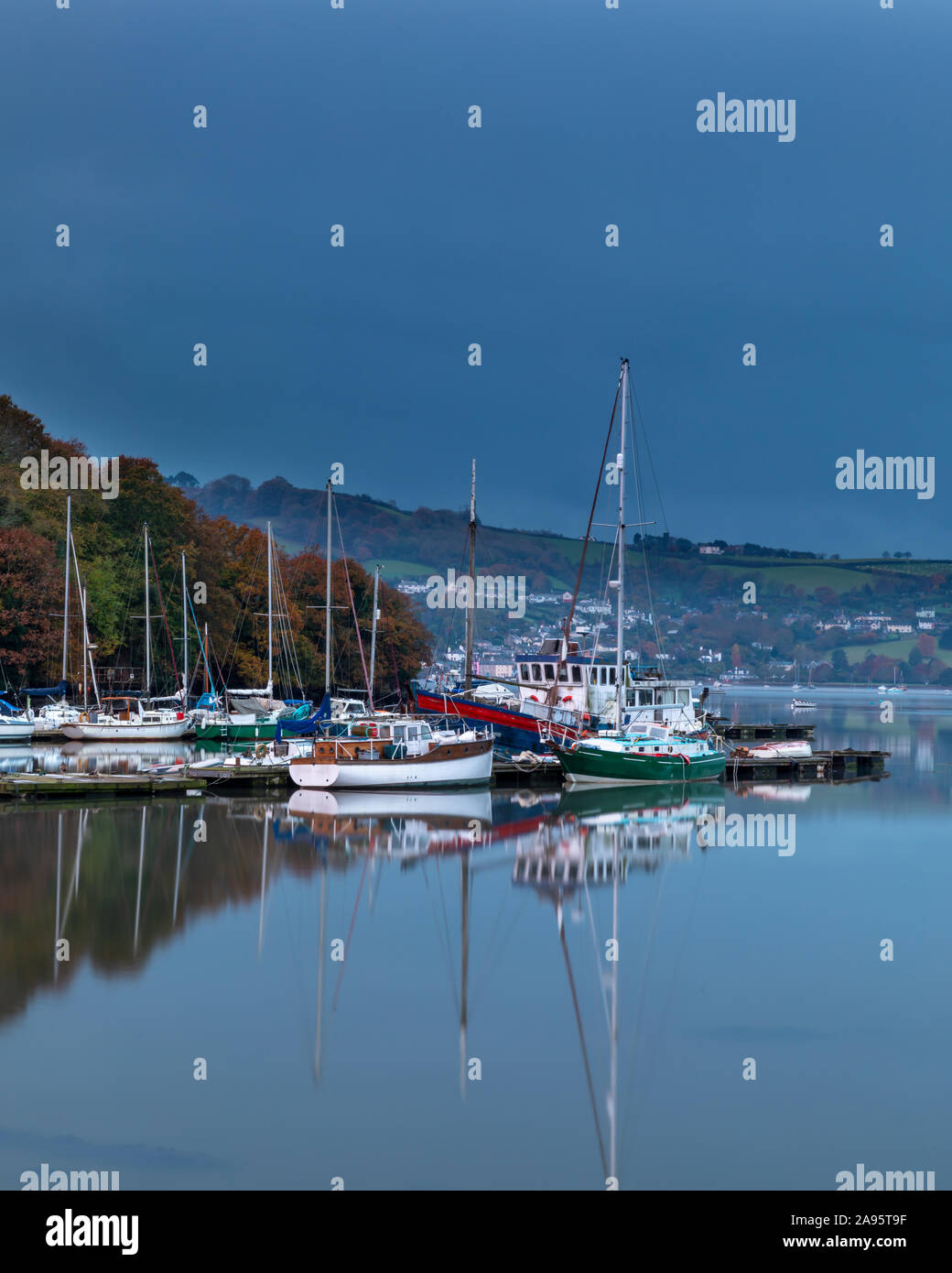 Alba a Dartside Quay, su Galmpton Creek, parte del fiume Dart estuario, vicino a Paignton, su nuvoloso, umido del mattino, con bellissimi riflessi. Foto Stock