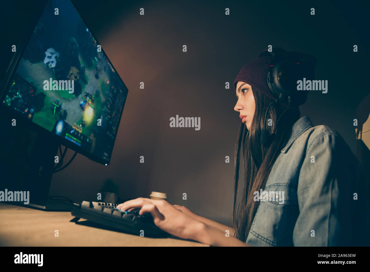 Di seguito basso angolo di vista profilo laterale foto di cyber sport donna concentrata su portando alla vittoria per il suo team premendo i pulsanti sulla tastiera Foto Stock