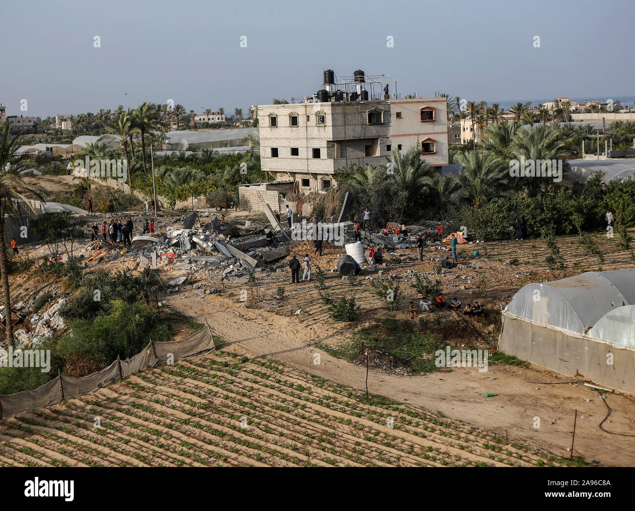 La striscia di Gaza, la Palestina. Xiii Nov, 2019. I palestinesi si radunano intorno ai resti di una casa distrutta in un attacco aereo israeliano nel sud della striscia di Gaza.La tensione sta salendo a Gaza dopo le brigate Al-Qods commander, il braccio armato di Gaza la resistenza base fazione Jihad islamica, Bahaa Abu Al-Atta morì in un israeliano airstrike. Credito: SOPA Immagini limitata/Alamy Live News Foto Stock