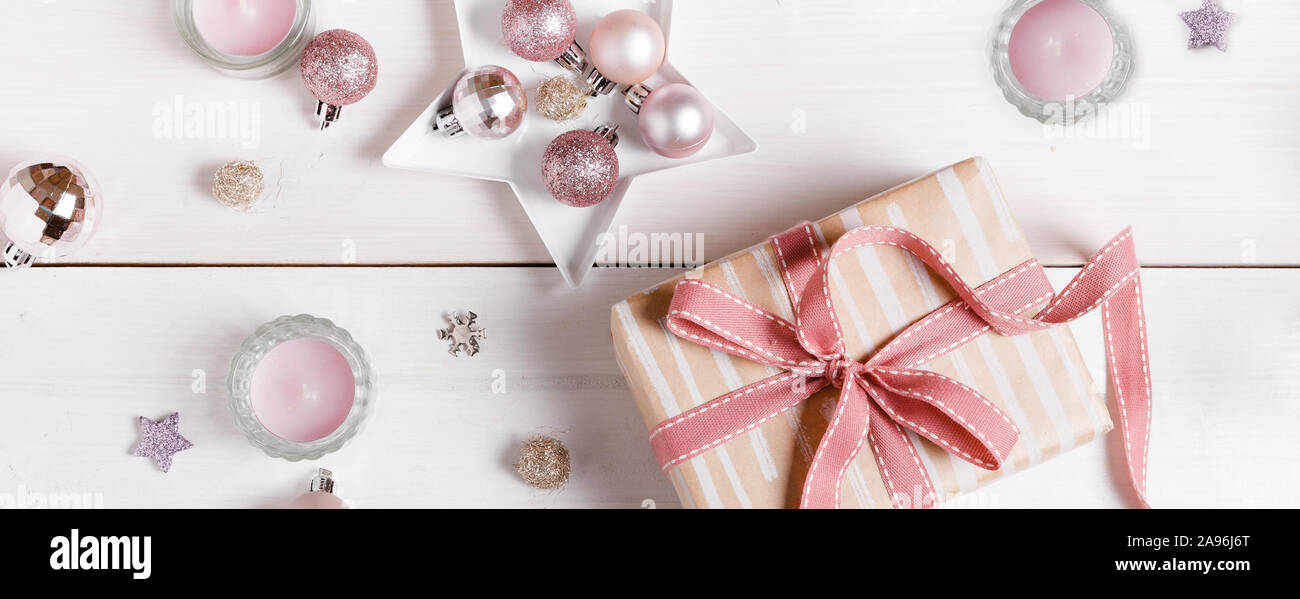 Preparazione regali di natale su una bianca tavolo in legno con decorazioni rosa Foto Stock