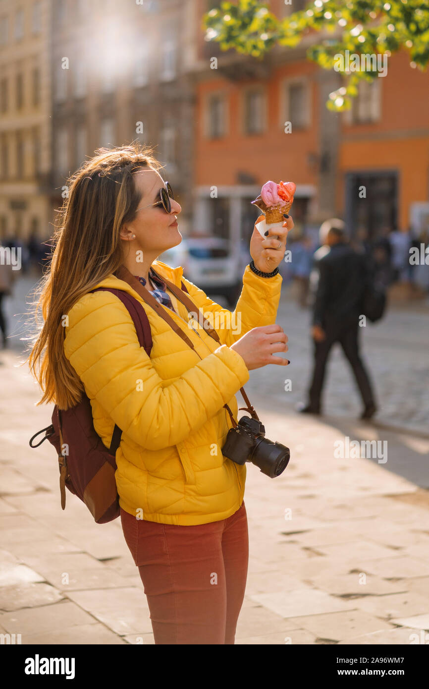 Giovane donna turistico, a mangiare il gelato, felice, ridere, luminosa giornata soleggiata, turistico fotocamera. Foto Stock