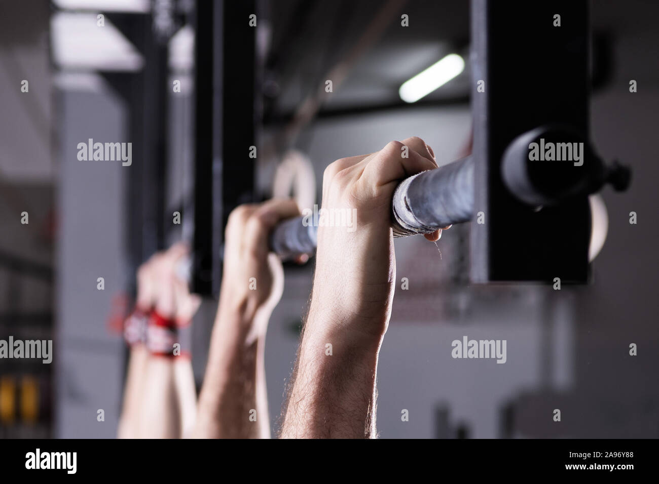Primo piano dettaglio dei maschi di mani tenendo un pull-up bar in una palestra. Climbing, funzionali di formazione e di concorrenza. Foto Stock