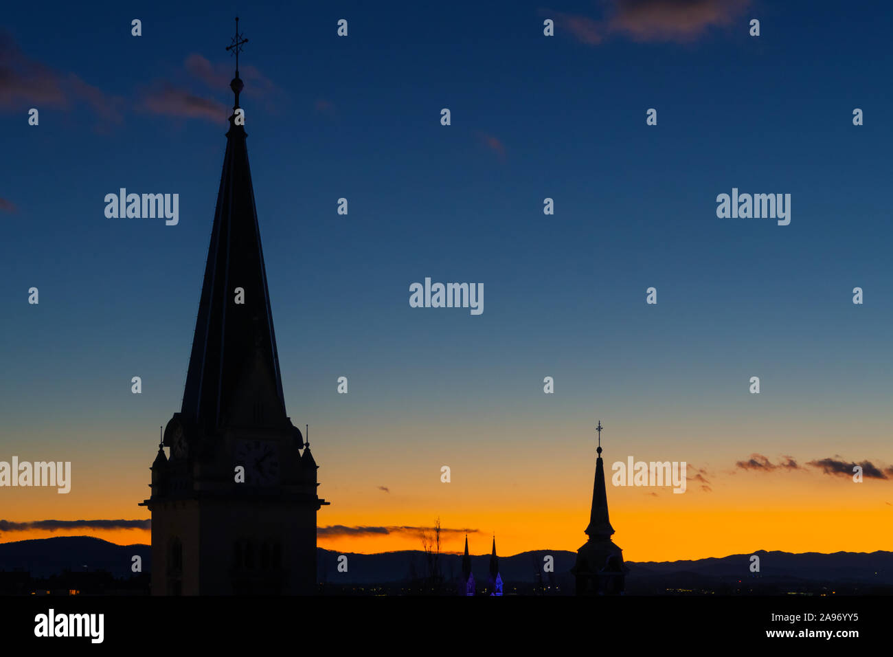Cityscape silhouette della chiesa cattolica delle torri a Lubiana su un meraviglioso blu arancione del cielo della sera sfondo. Paesaggi urbani e i concetti di religione. Foto Stock
