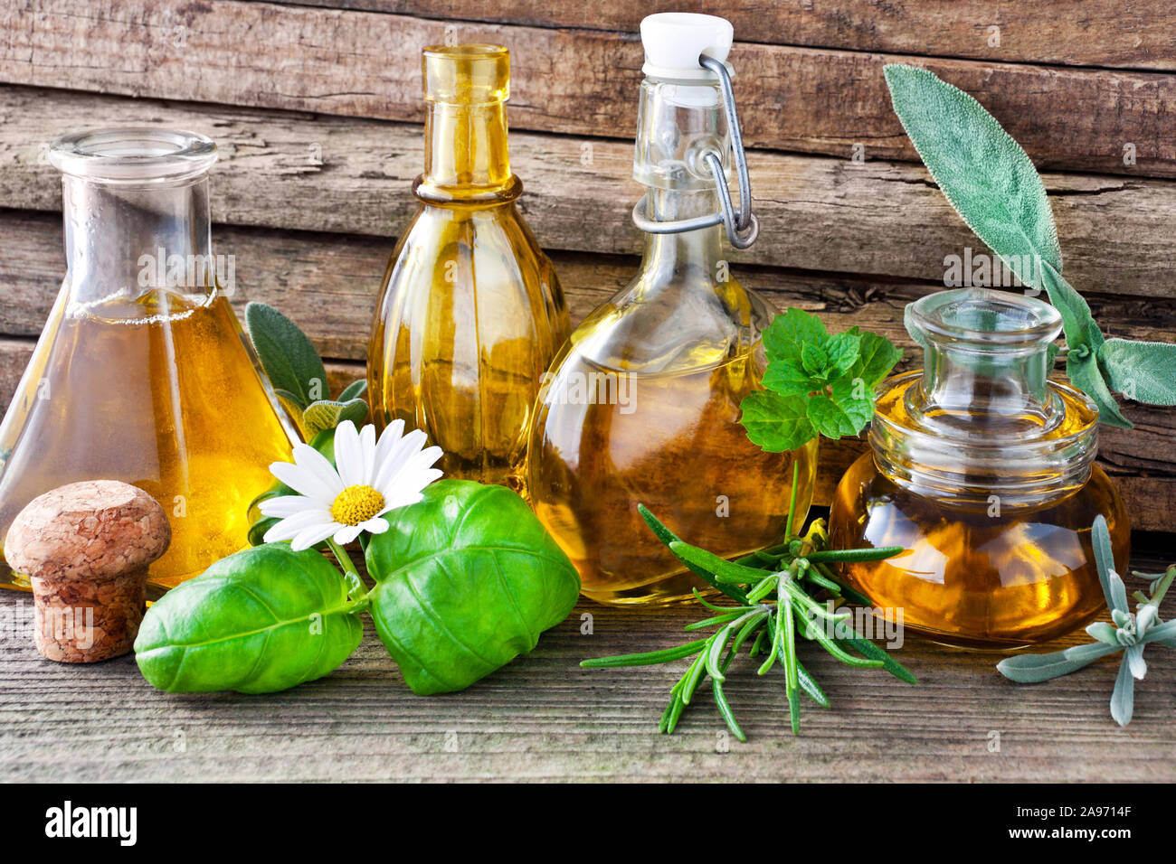 Olio ed erbe su tavola di legno Foto Stock