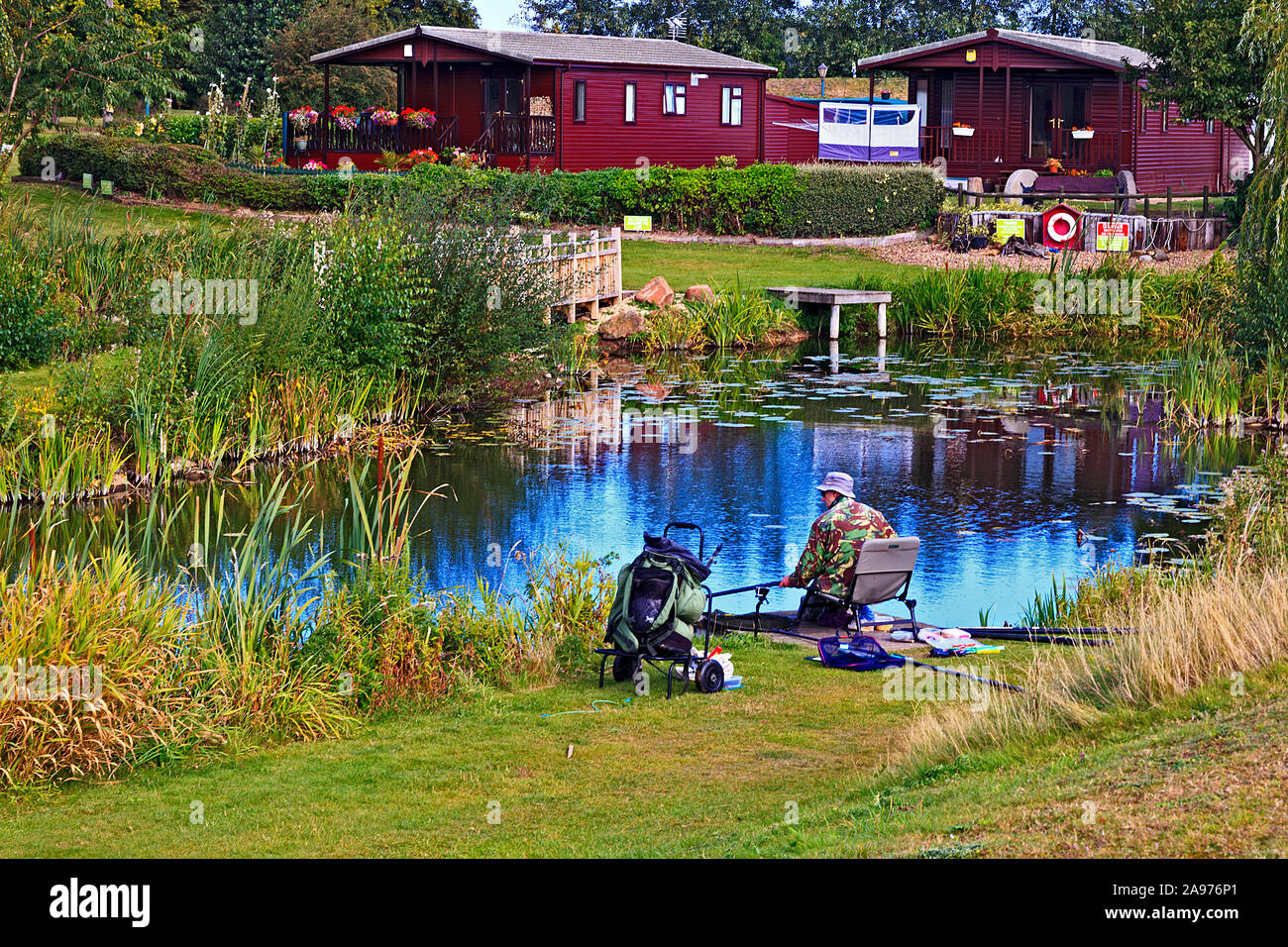 Uomo di pesca sul park home sito con laghi Foto Stock
