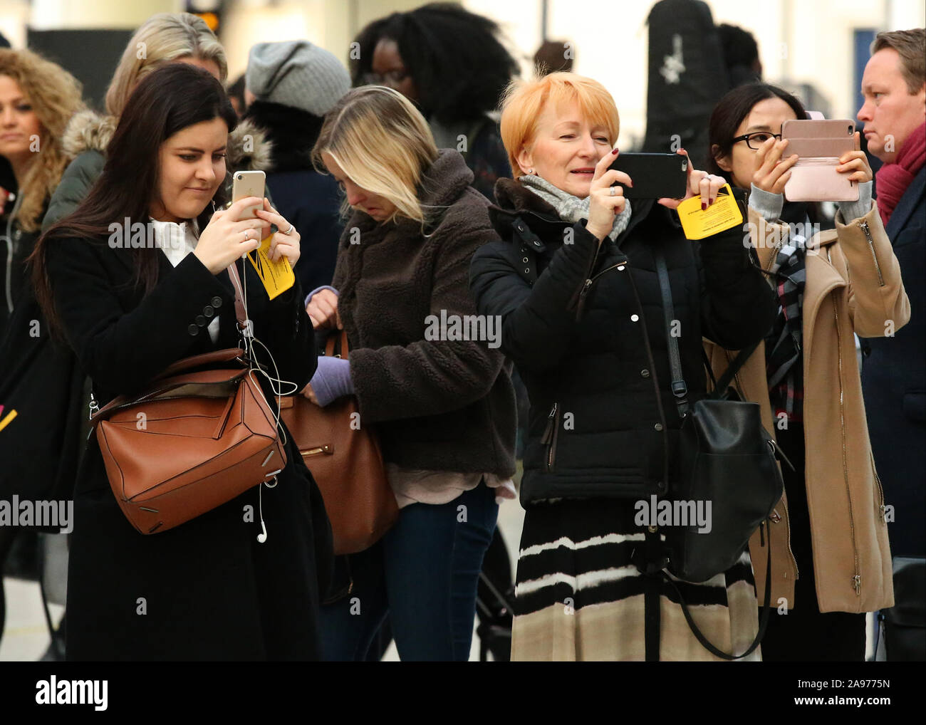Pendolari film 40's band della Kal Katsuta che svolgono presso la stazione di Waterloo, durante una salute mentale UK foglietto fuori mano, la stazione di Waterloo, Londra. Foto Stock