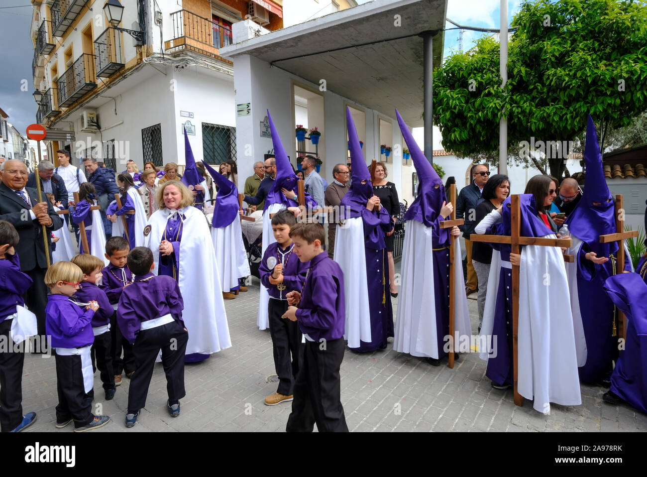 Processione della comunità locale che indossa i capiroti viola, portando Gesù e la Croce durante la settimana Santa. Carcabuey, Provincia di Cordova, Andalusia. Spagna Foto Stock