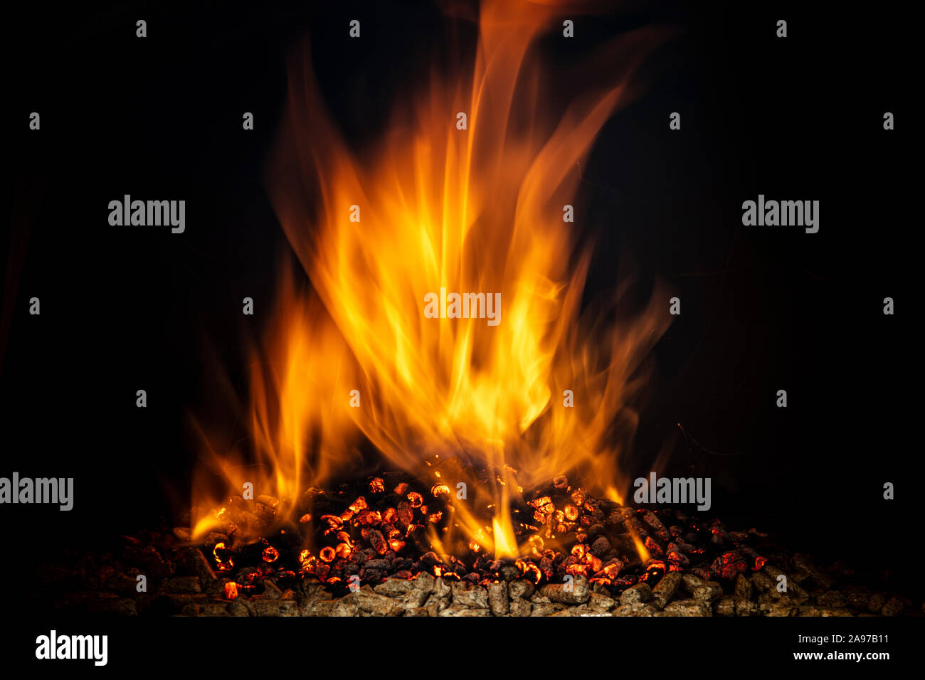 Pellet di legno bruciare con una fiamma viva. combustibile ecologico concetto. Foto Stock