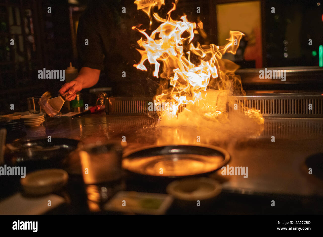 Chef di Teppanyaki preparare la piastra di metallo con fiamme di fuoco  pronto per la cottura di cucina Giapponese Foto stock - Alamy
