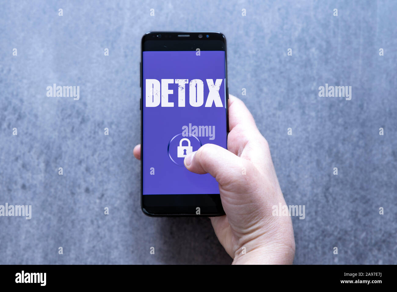 Digital detox concetto mano femmina holding smartphone con testo detox e il simbolo di bloccaggio del pulsante. Foto Stock
