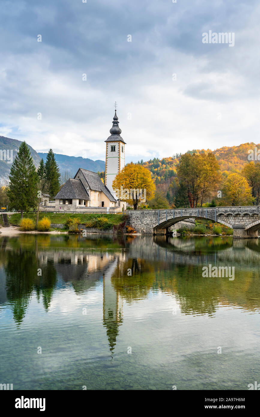 La Chiesa di San Giovanni Battista si riflette nel lago di Bohinj, Slovenia, l'Europa. Foto Stock