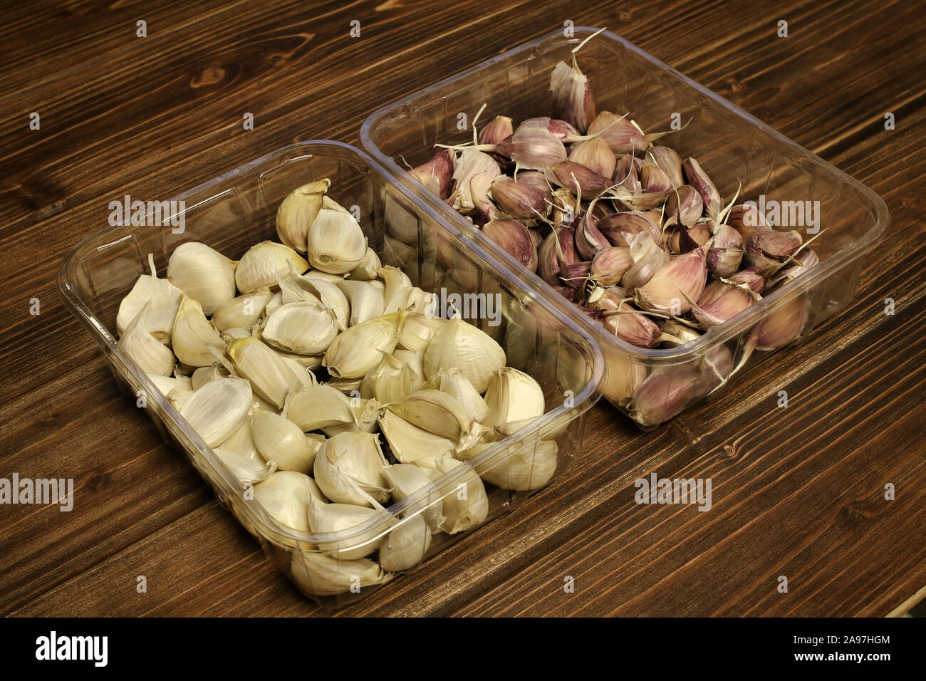 Vista dettagliata del bianco e del rosa / viola / viola varietà di spicchi di aglio ( Allium sativum), Piantine preparate per la semina autunnale, aglio in una plastica Foto Stock