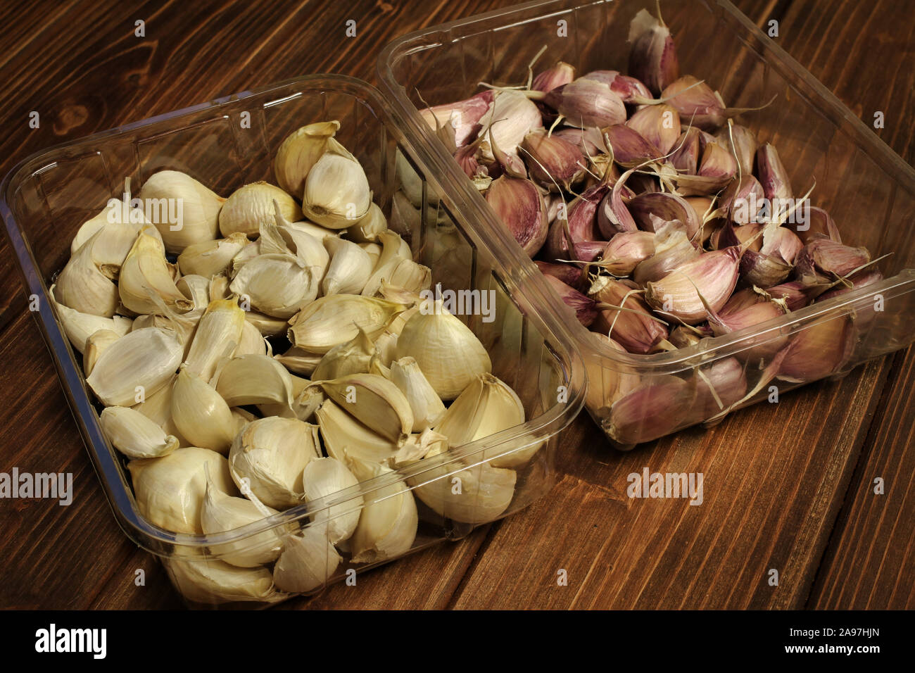 Vista dettagliata del bianco e del rosa / viola / viola varietà di spicchi di aglio ( Allium sativum), Piantine preparate per la semina autunnale, aglio in una plastica Foto Stock