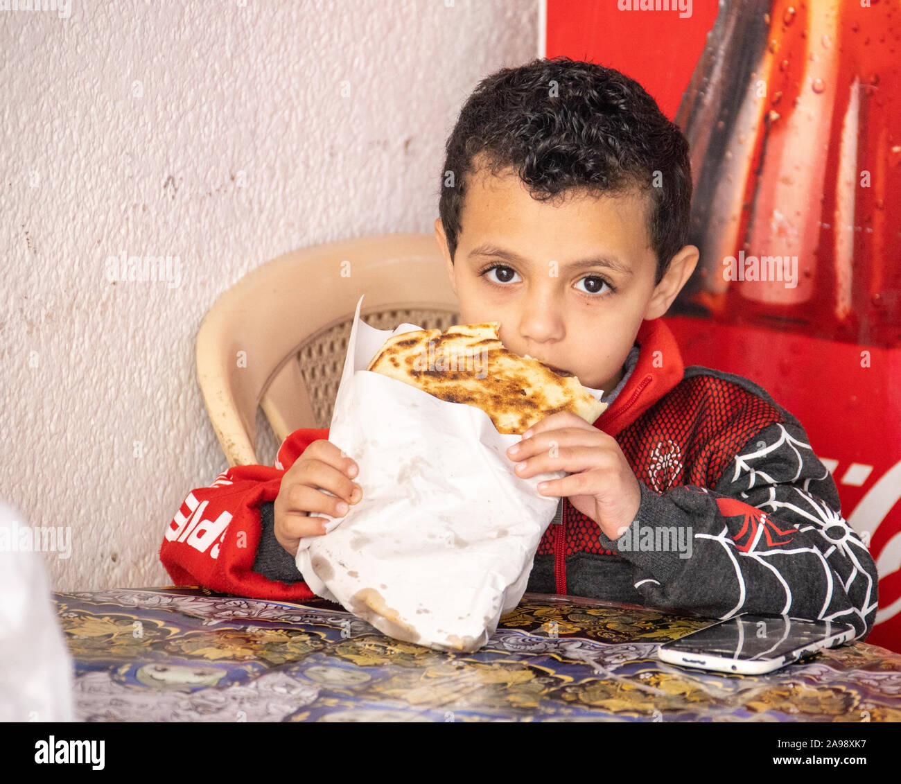 Ragazzo locale di mangiare in zona Souk, Sidone (Saida), Libano Foto Stock