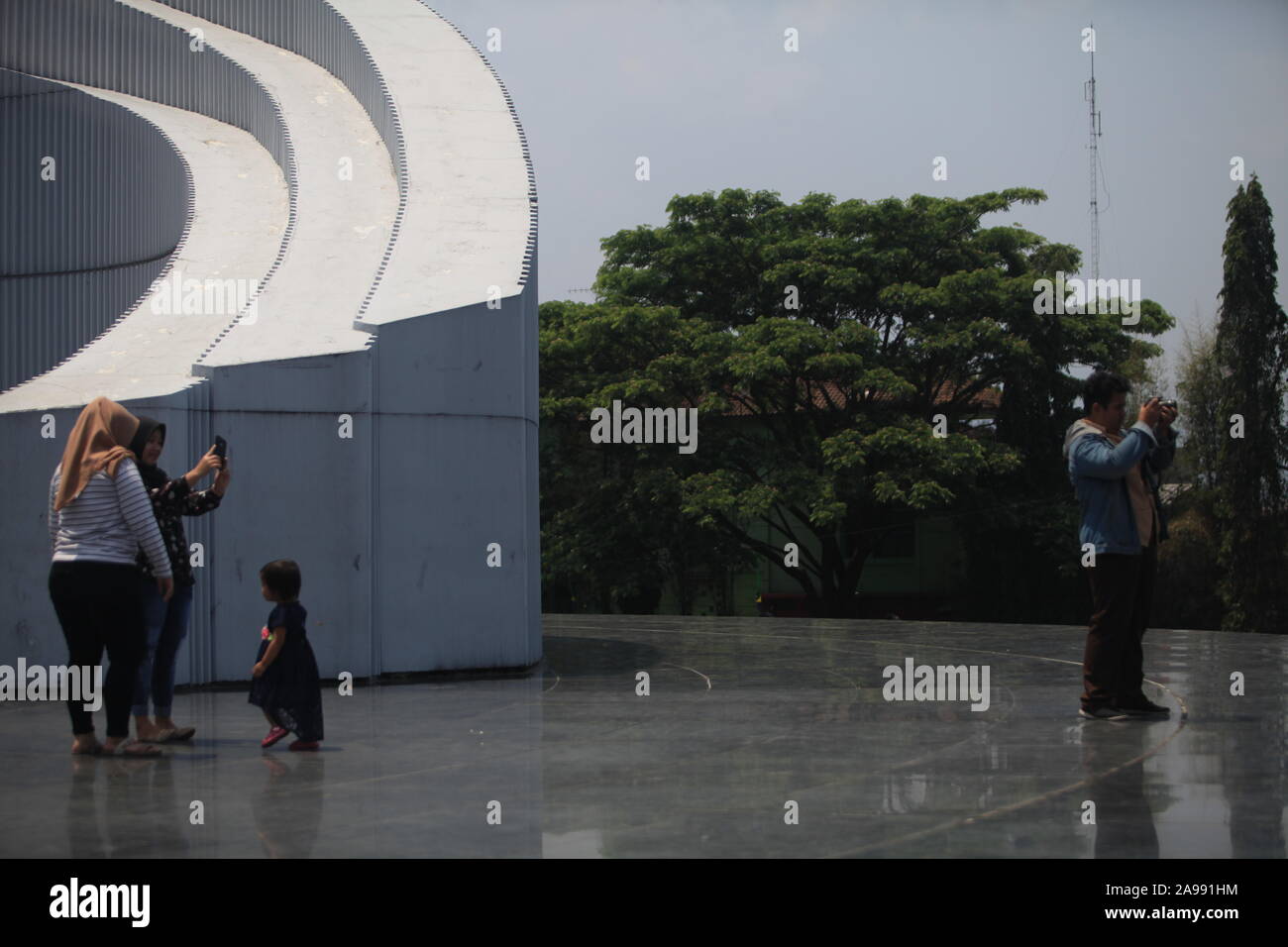 Una madre è a fotografare il suo figlio e suo fratello, in un luogo di lotta monumento in Bandung. Foto Stock