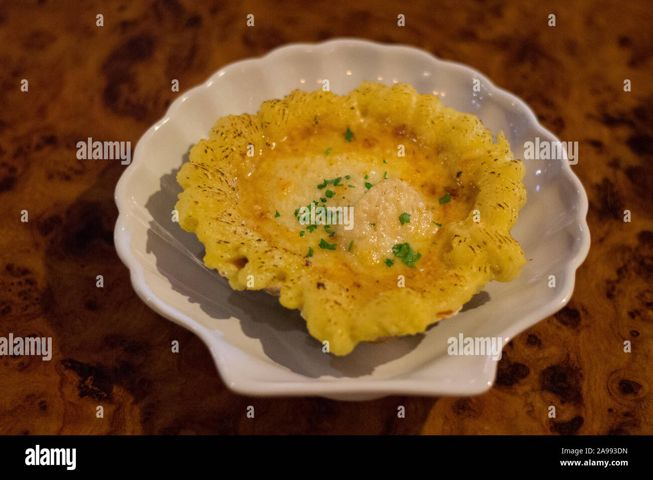 Smerlo aux capesante Gratin soffritto nel burro, flambed con il brandy e sormontato da un formaggio poi cotto Foto Stock