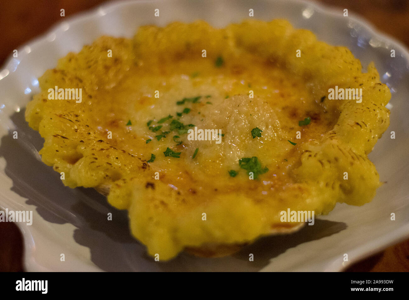 Smerlo aux capesante Gratin soffritto nel burro, flambed con il brandy e sormontato da un formaggio poi cotto Foto Stock