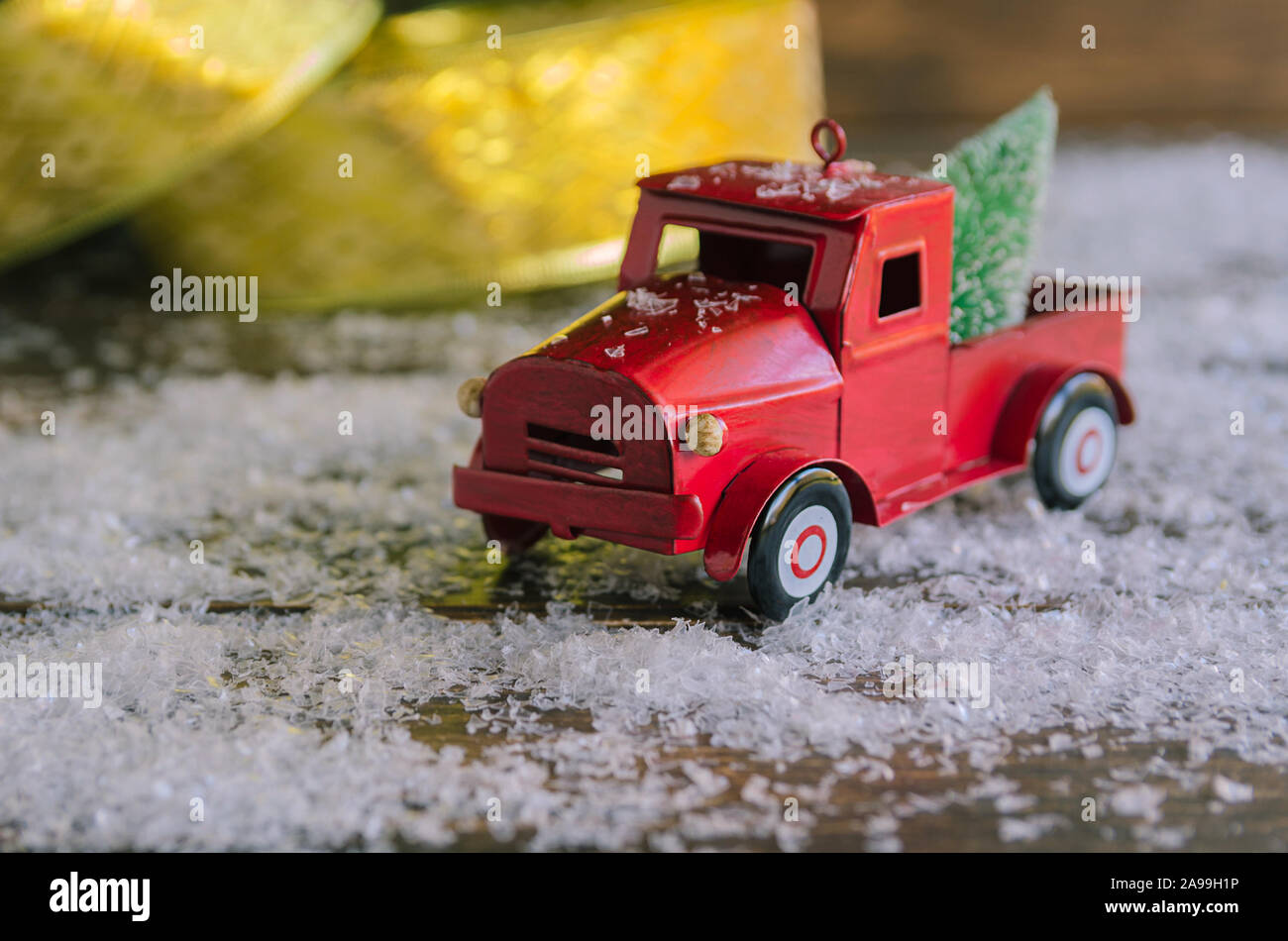 Auto rossa che porta un Natale abete sulla neve sfondo per celebrata Buon Natale. Foto Stock