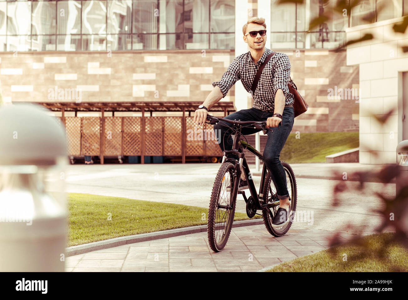 Gioiosa giovane uomo in sella alla sua bicicletta con piacere Foto Stock