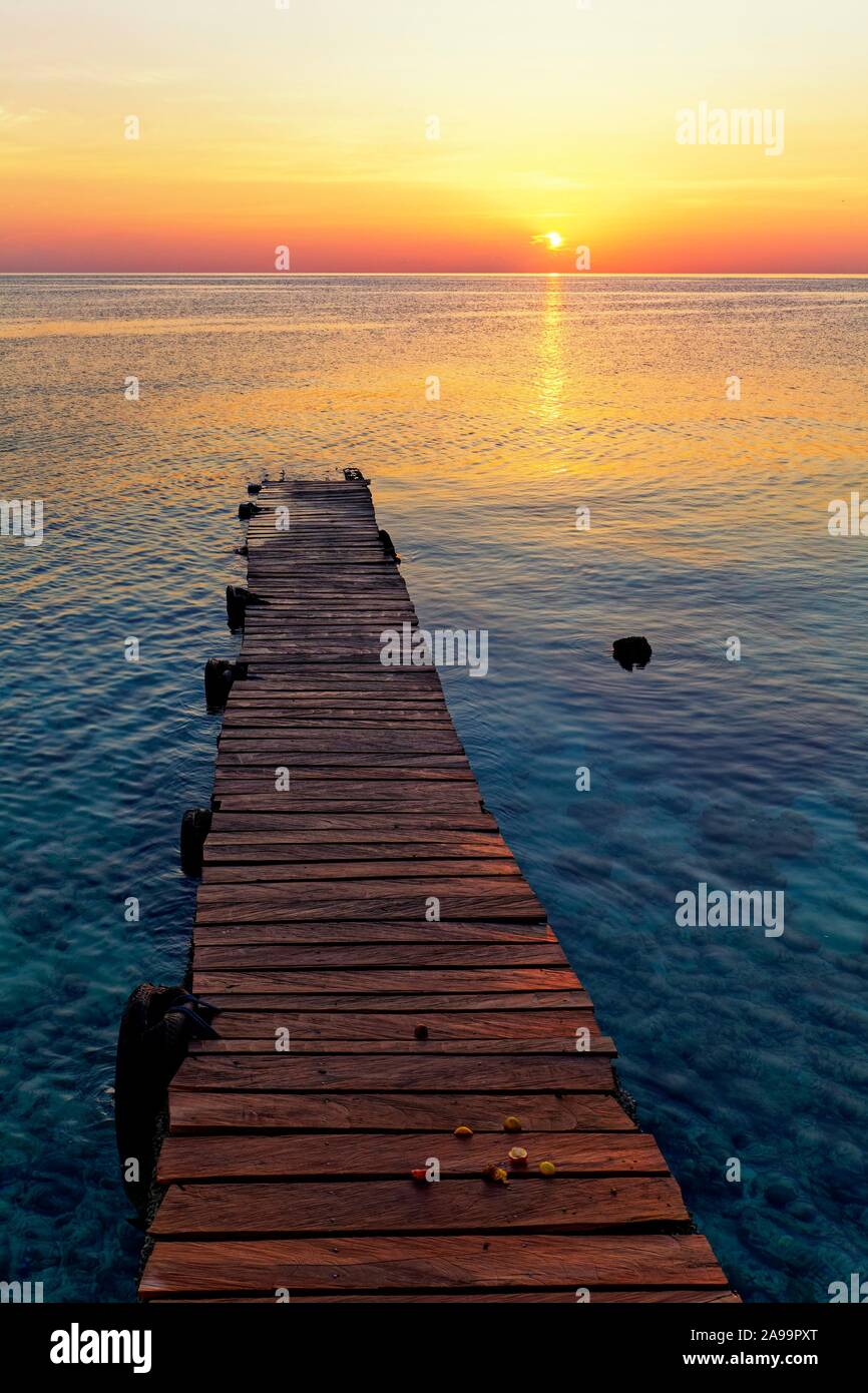 Il molo, pontile in legno in mare al tramonto, Selayar Dive Resort, Selayar isola, a Sud di Sulawesi, Sulawesi, Indonesia Foto Stock