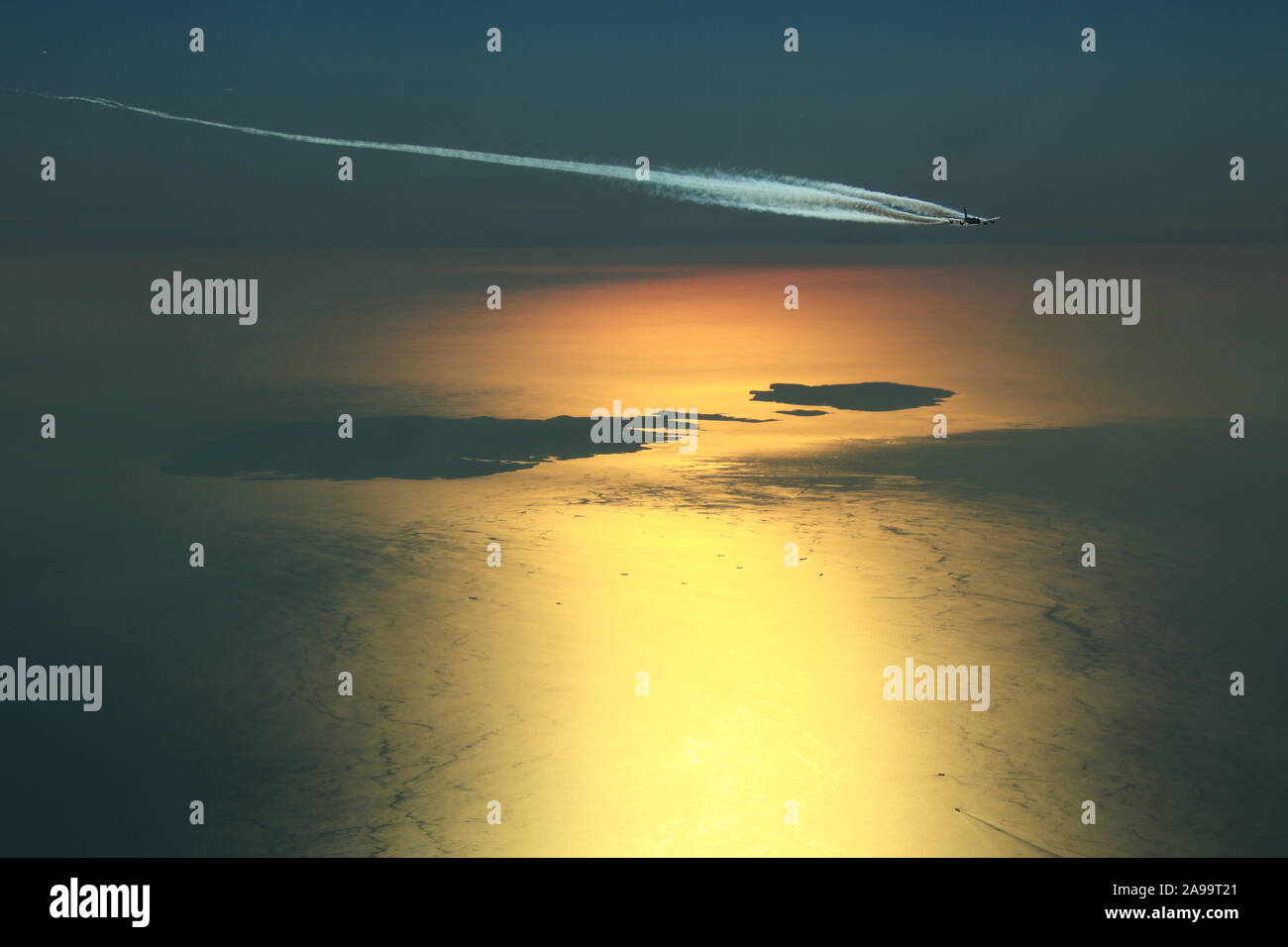 I gas di scarico del motore contrails formando dietro un Airbus A380 Super Jumbo mentre sorvolo l arcipelago maltese durante un bel tramonto Foto Stock