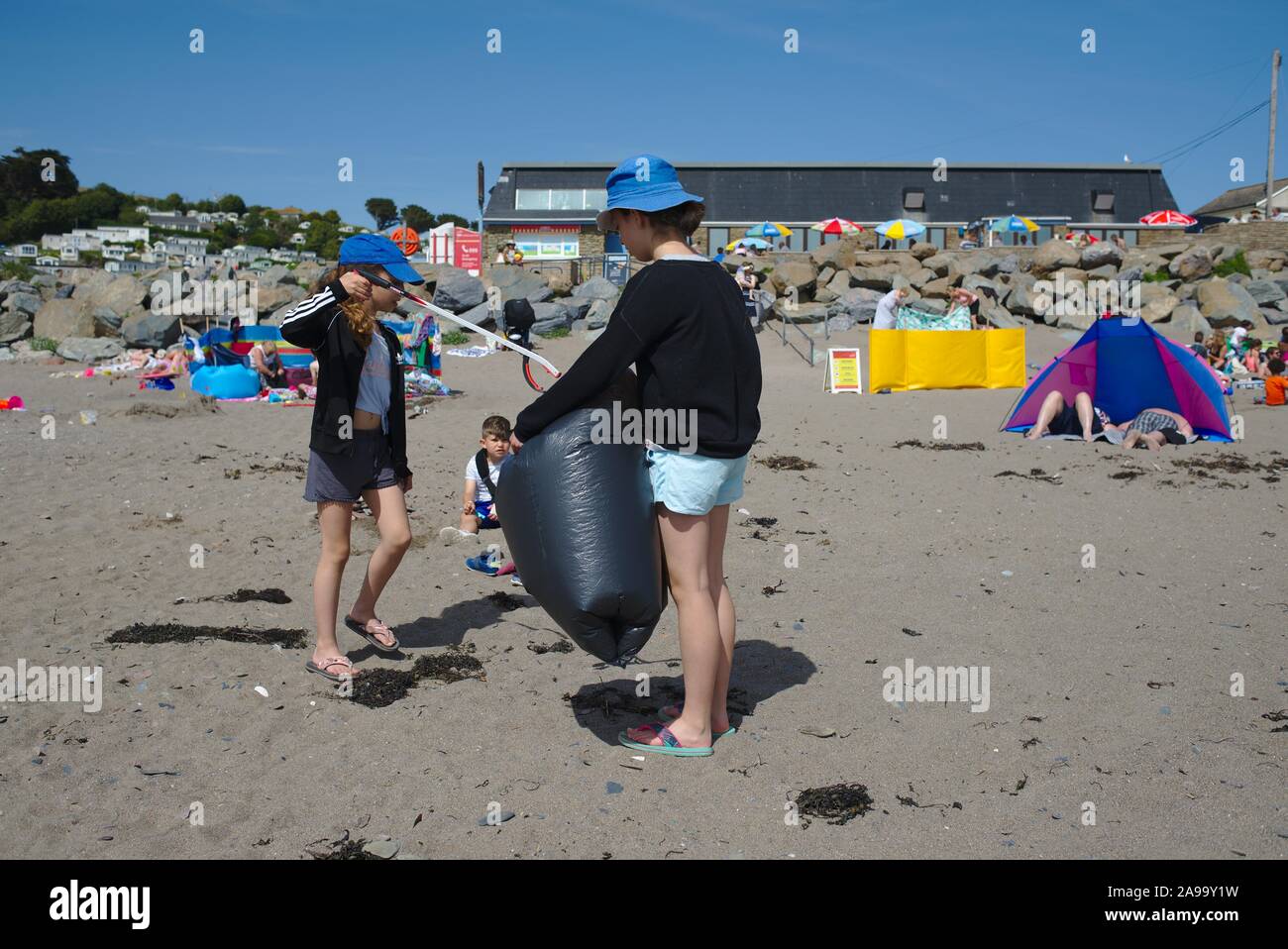 Spiaggia pulita fino ai bambini di aiuto da parte di volontariato a fare cinque minuti di lettiera il prelievo a Chalisborough. Devon UK Foto Stock