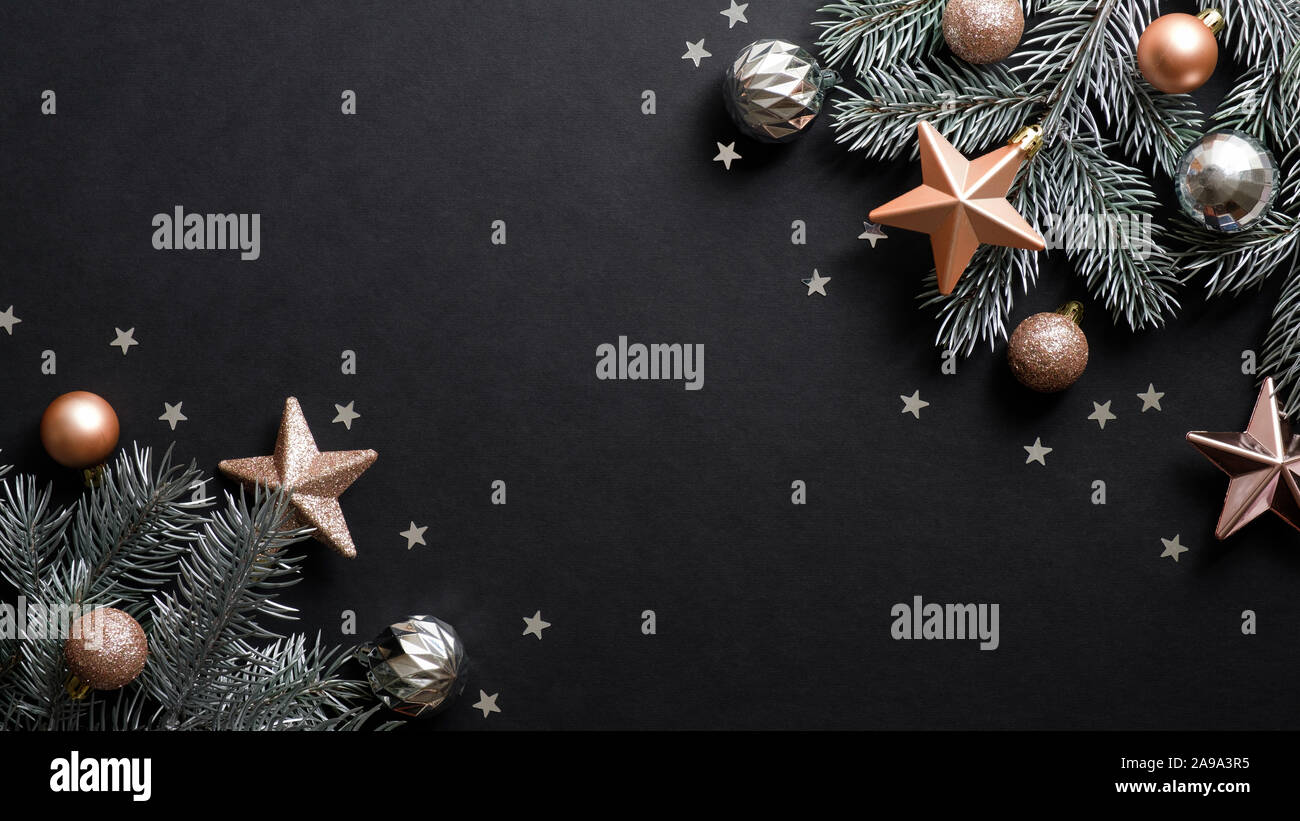 Banner di natale. Albero di Natale decorato rami color rame stelle e palle su sfondo nero. Appartamento laico, vista dall'alto. Xmas banner mockup con copia Foto Stock