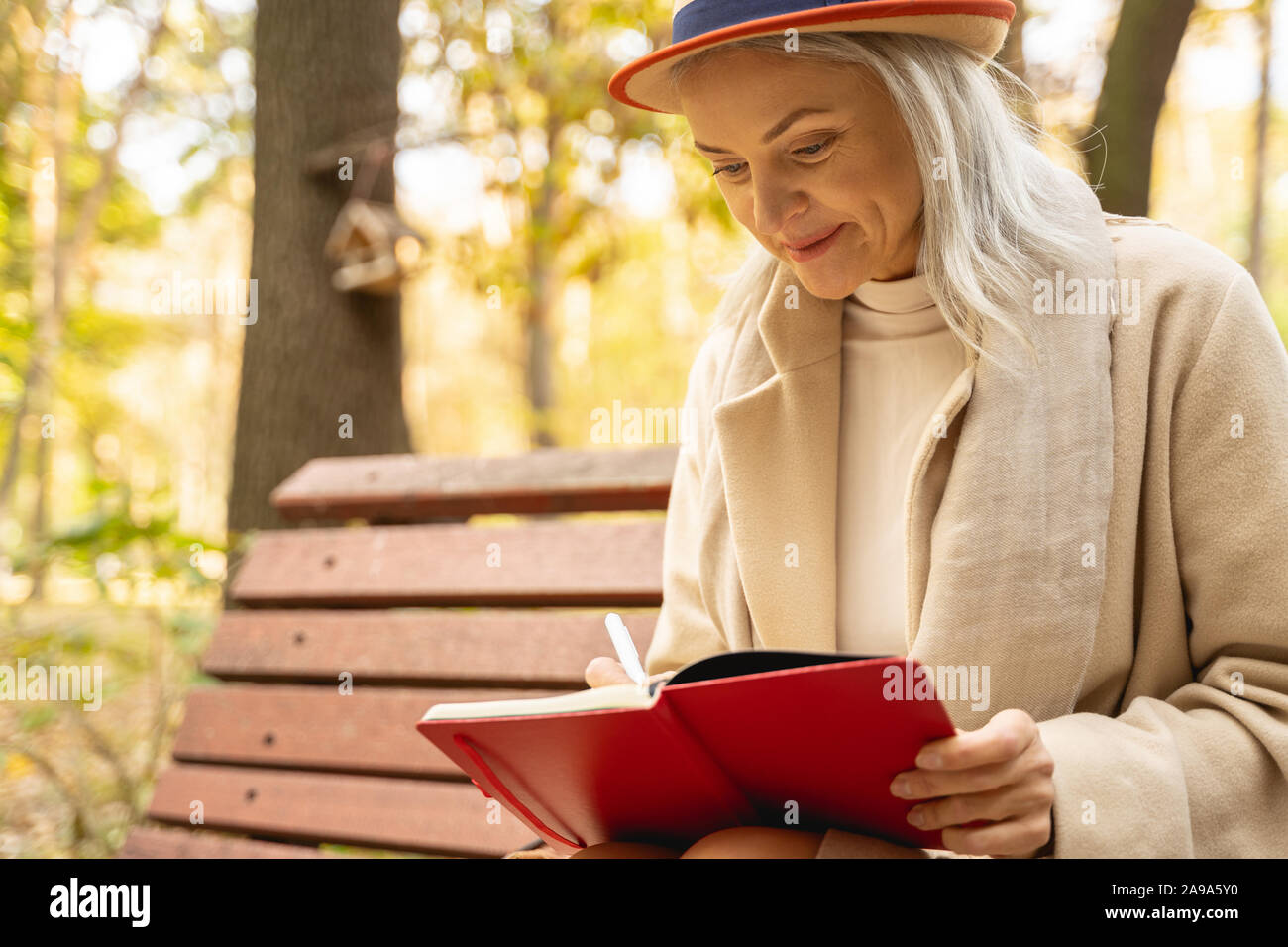 Donna elegante rendendo note nel suo blocco note Foto Stock