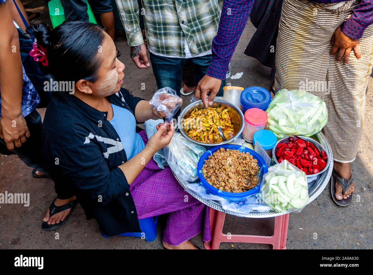 Una donna locale vendono spuntini presso il Mercato della Giada, Mandalay Myanmar Foto Stock
