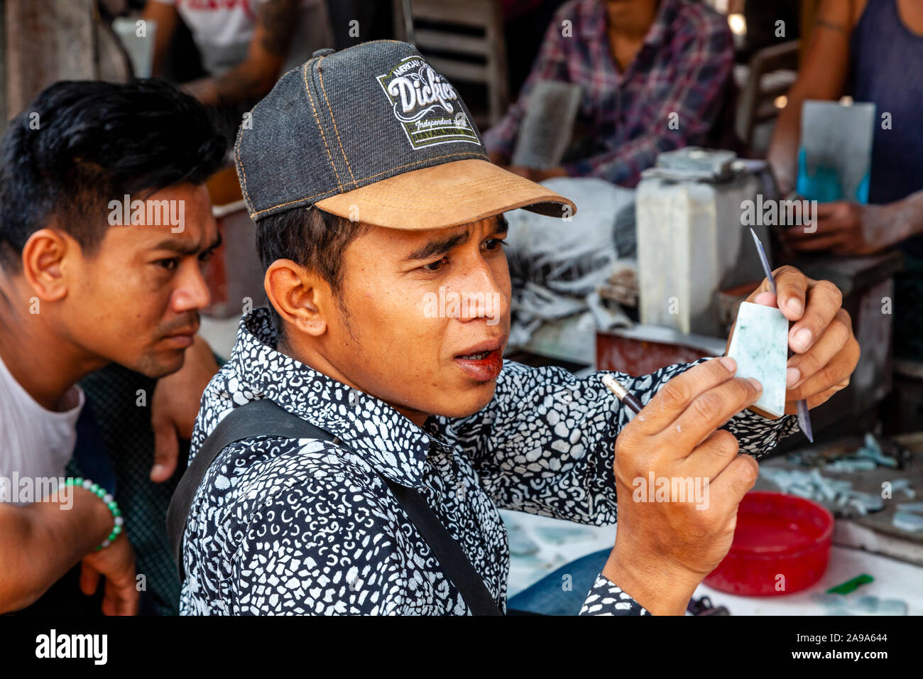 Un acquirente esamina le pietre di giada al Mercato della Giada, Mandalay Myanmar. Foto Stock
