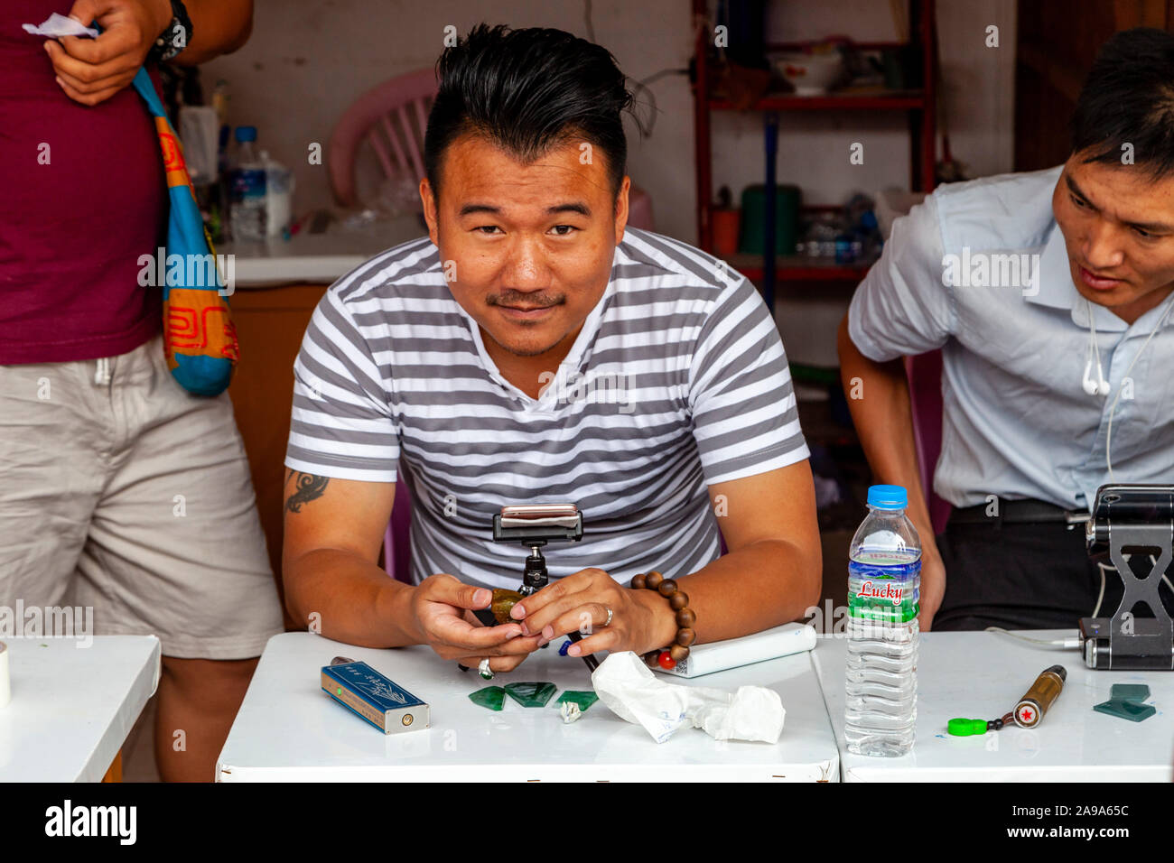 I concessionari esaminando Jade al Mercato della Giada, Mandalay Myanmar. Foto Stock