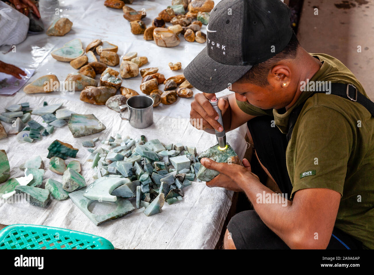 Gli acquirenti di esaminare la Giada presso il Mercato della Giada, Mandalay Myanmar. Foto Stock