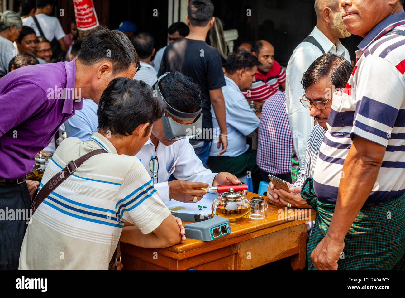 Un concessionario esaminando Jade al Mercato della Giada, Mandalay Myanmar. Foto Stock