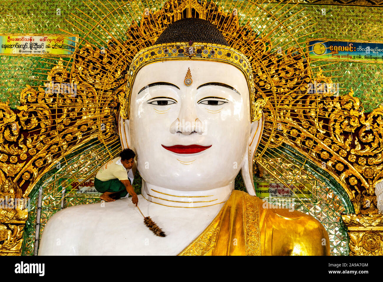 Un uomo che pulisce una grande statua del Buddha dentro il più presto Oo Pon Nya Shin Paya, Sagaing, Mandalay Myanmar. Foto Stock