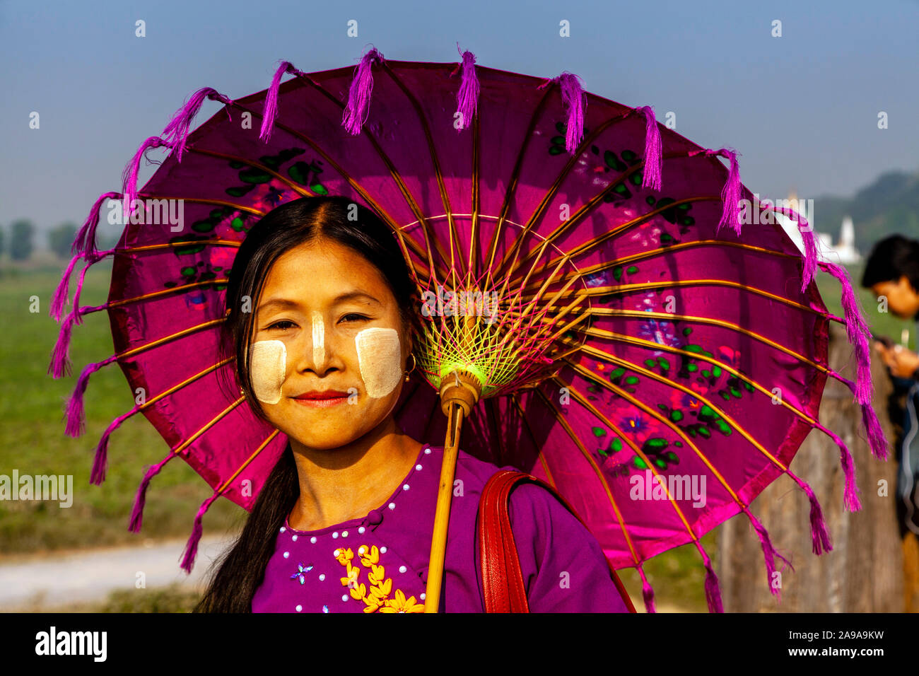 Una giovane donna birmana con un ombrellone in piedi su U Bein Bridge, Amarapura, Mandalay Myanmar. Foto Stock