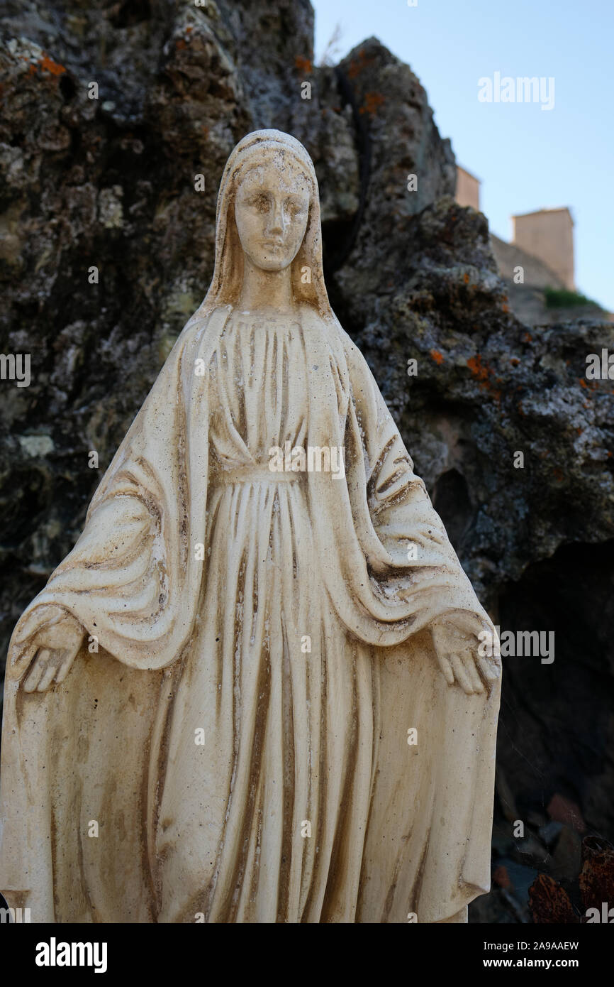 Una statua di pietra vergine Maria la figura con le braccia aperte in Corte Haute-Corse Corsica Francia - angelo custode guardando verso il basso Foto Stock